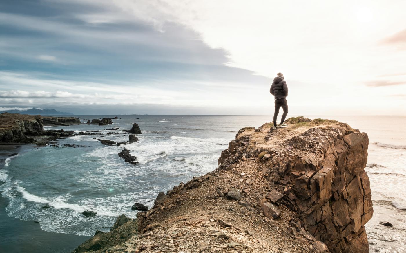 man on edge of cliff by Sead Dedić courtesy of Unsplash.
