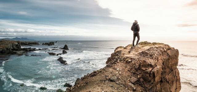 man on edge of cliff by Sead Dedić courtesy of Unsplash.